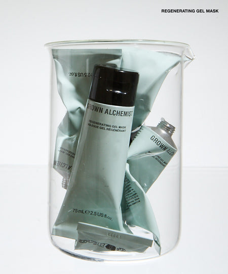 A clear glass jar filled with multiple tubes of GROWN ALCHEMIST regenerating gel mask in a pale sage green color, set against a clean white background.