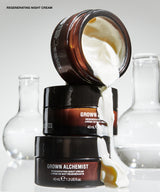 Three cosmetic cream jars stacked and tipped over with thick white cream dripping out, set against a clean light gray background with blurred glass flask shapes. Visible text includes 'REGENERATING NIGHT CREAM'.