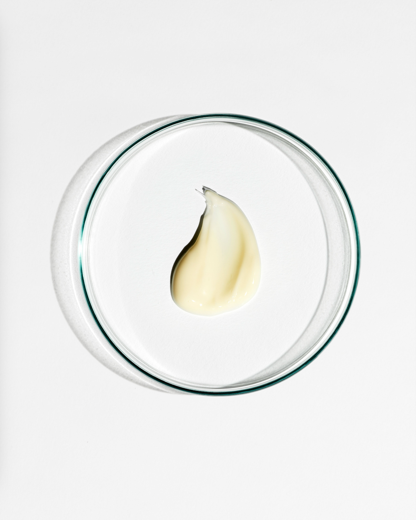 Clear dish with a dollop of cream on a white background