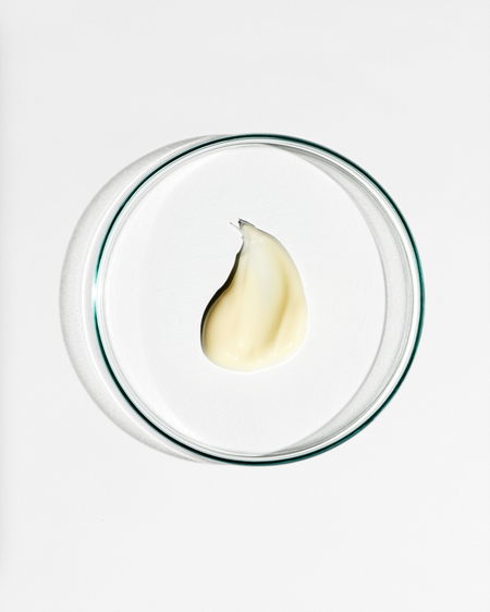 Clear dish with a dollop of cream on a white background