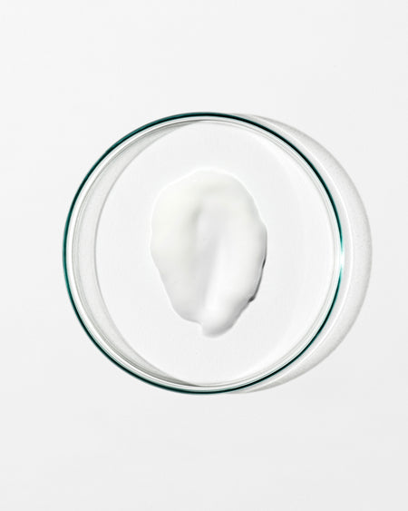 Glass bowl with a white creamy substance on a white background