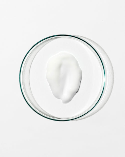 Glass bowl with a white creamy substance on a white background