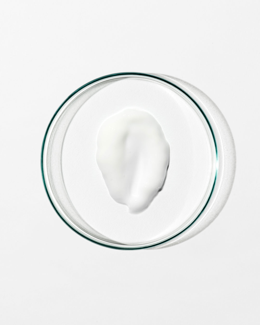 Glass bowl with a white creamy substance on a white background