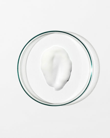 Glass bowl with a white creamy substance on a white background