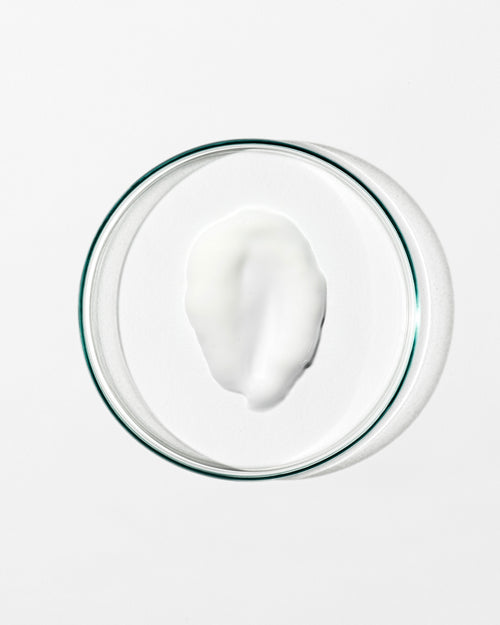 Glass bowl with a white creamy substance on a white background