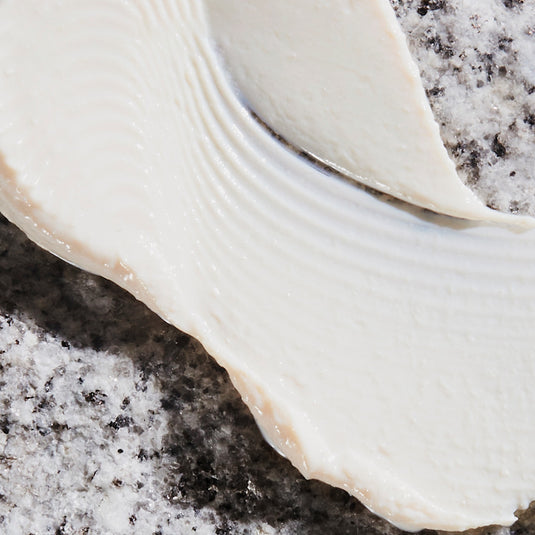 Close-up of Regenerating Hand Cream on a gray stone surface
