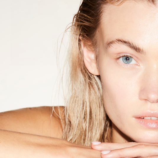 Close-up of a person with blonde hair and blue eyes on a plain background