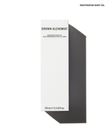 A tall, narrow white box labeled 'GROWN ALCHEMIST' and 'RESTORATIVE BODY OIL' on a white background with a dark gray cast shadow. Small text at the top right reads 'RESTORATIVE BODY OIL'.