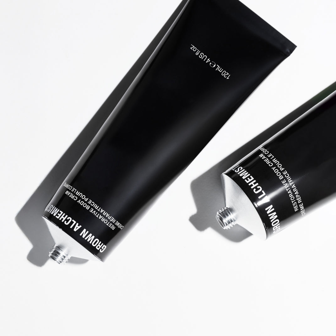 Two black tubes of Grown Alchemist product on a white background
