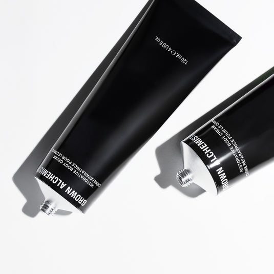 Two black tubes of Grown Alchemist hair product on a white background