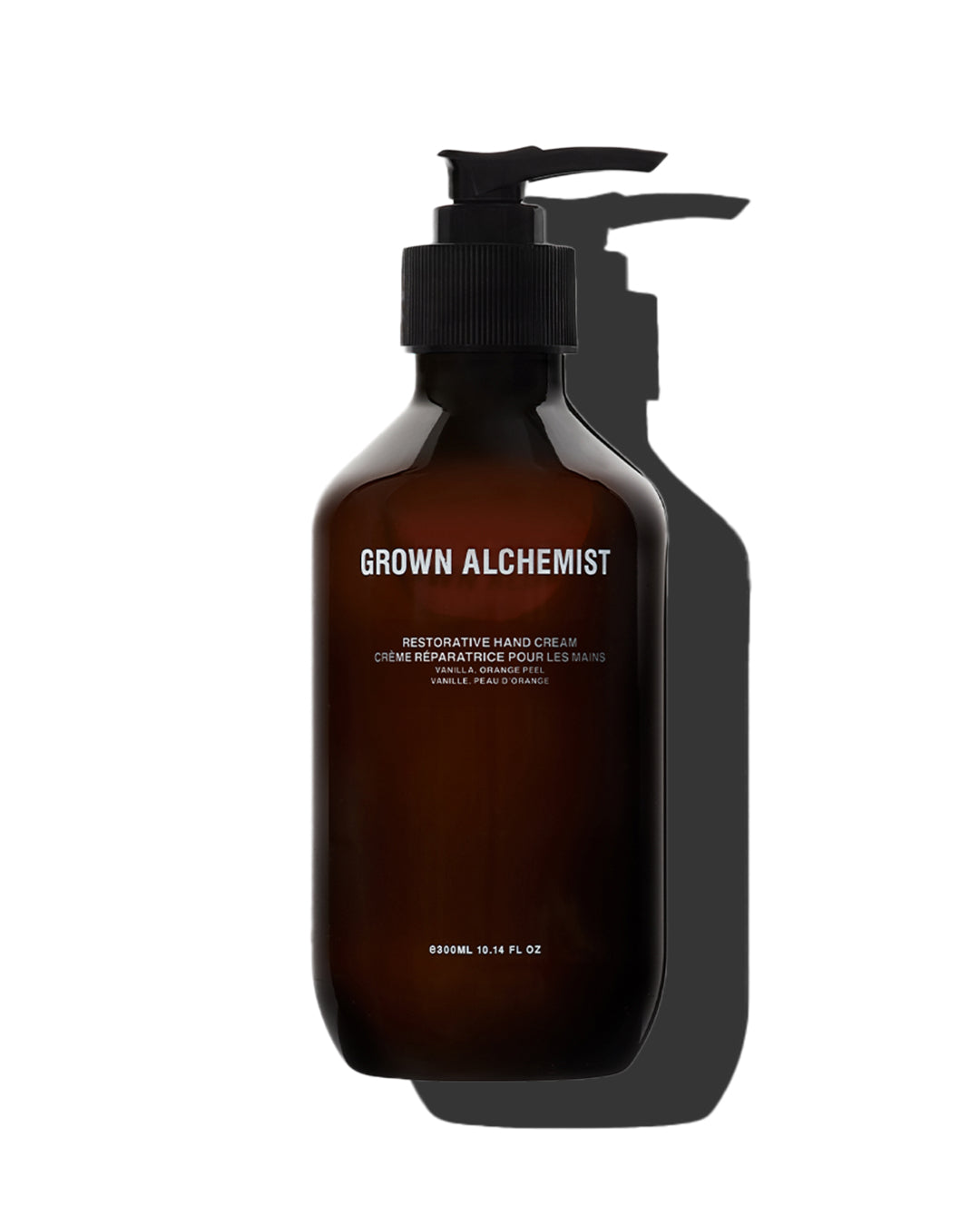 Brown bottle with pump of Grown Alchemist hand cream on a white background