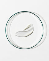 White cream on a clear glass lid against a white background