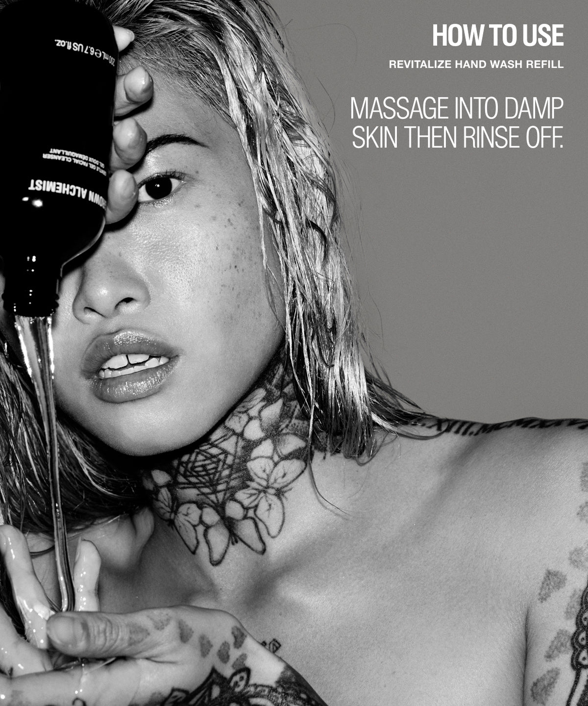 Black and white promotional image showing a tattooed woman holding a hand wash bottle near her face, with text reading 'HOW TO USE REVITALIZE HAND WASH MASSAGE INTO DAMP SKIN THEN RINSE OFF.'.