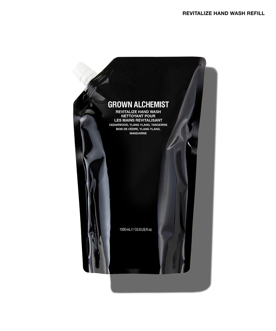 A black refill pouch of Grown Alchemist Revitalize Hand Wash on a white background with a gray shadow.