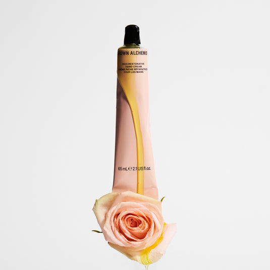 Skincare bottle with a rose on a light gray background