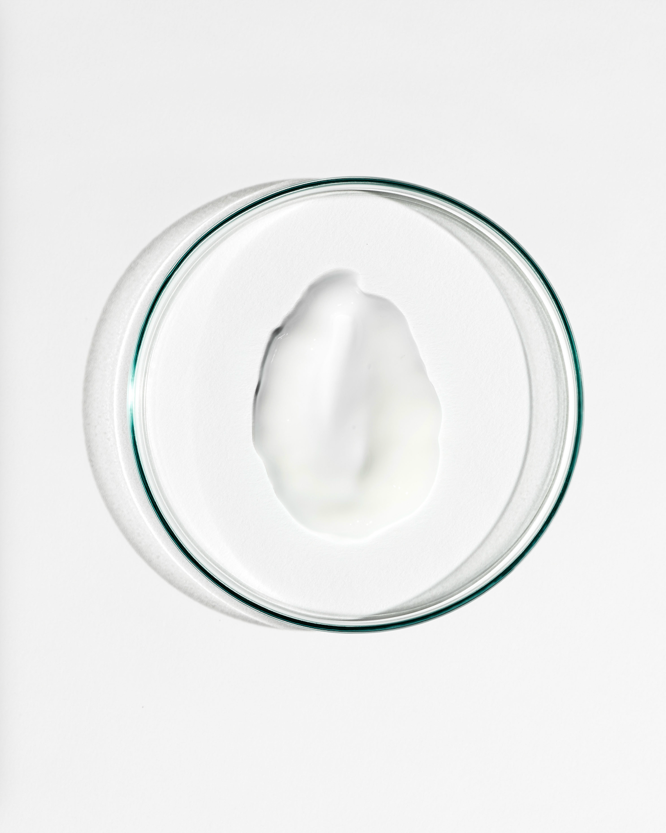 Glass bowl with a white cream on a white background