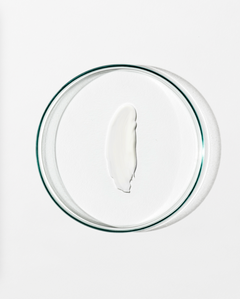 Clear dish with a dollop of white cream against a white background