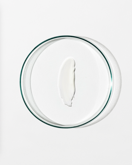 Clear dish with a dollop of white cream against a white background