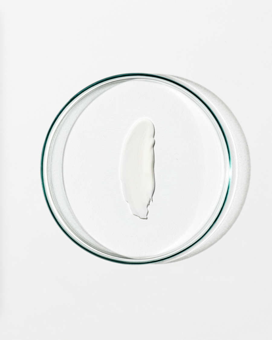 Clear dish with a dollop of white cream against a white background