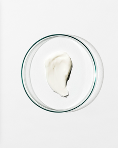 Glass bowl with swatch of moisturiser on a white background