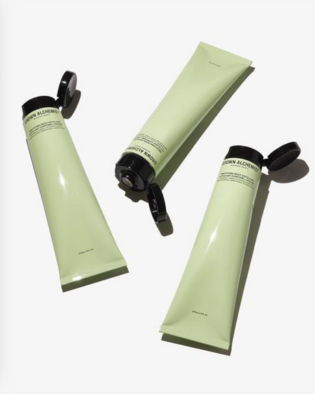 Three green Grown Alchemist tubes with black caps on a white background