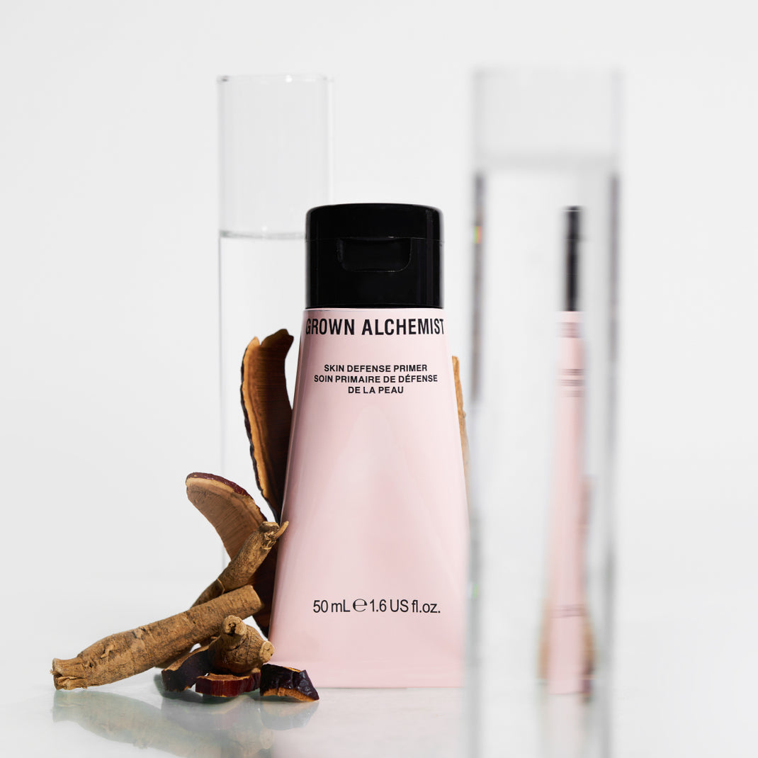Pink bottle with black cap labeled 'Skin Defense Primer' on a white background