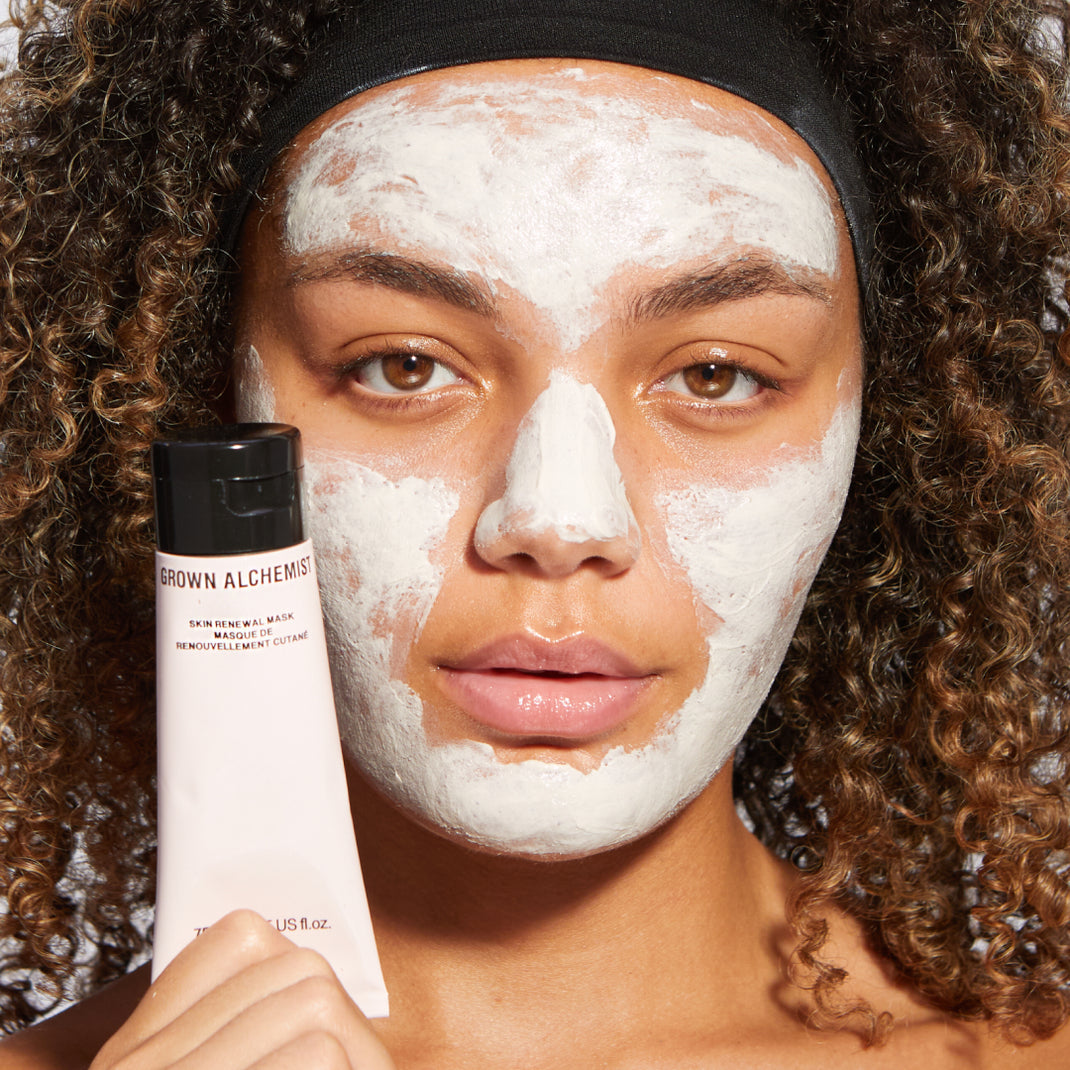 Woman applying a face mask with Skin Renewal Mask tube in the foreground