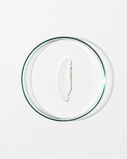 Clear glass bowl with cream on a white background