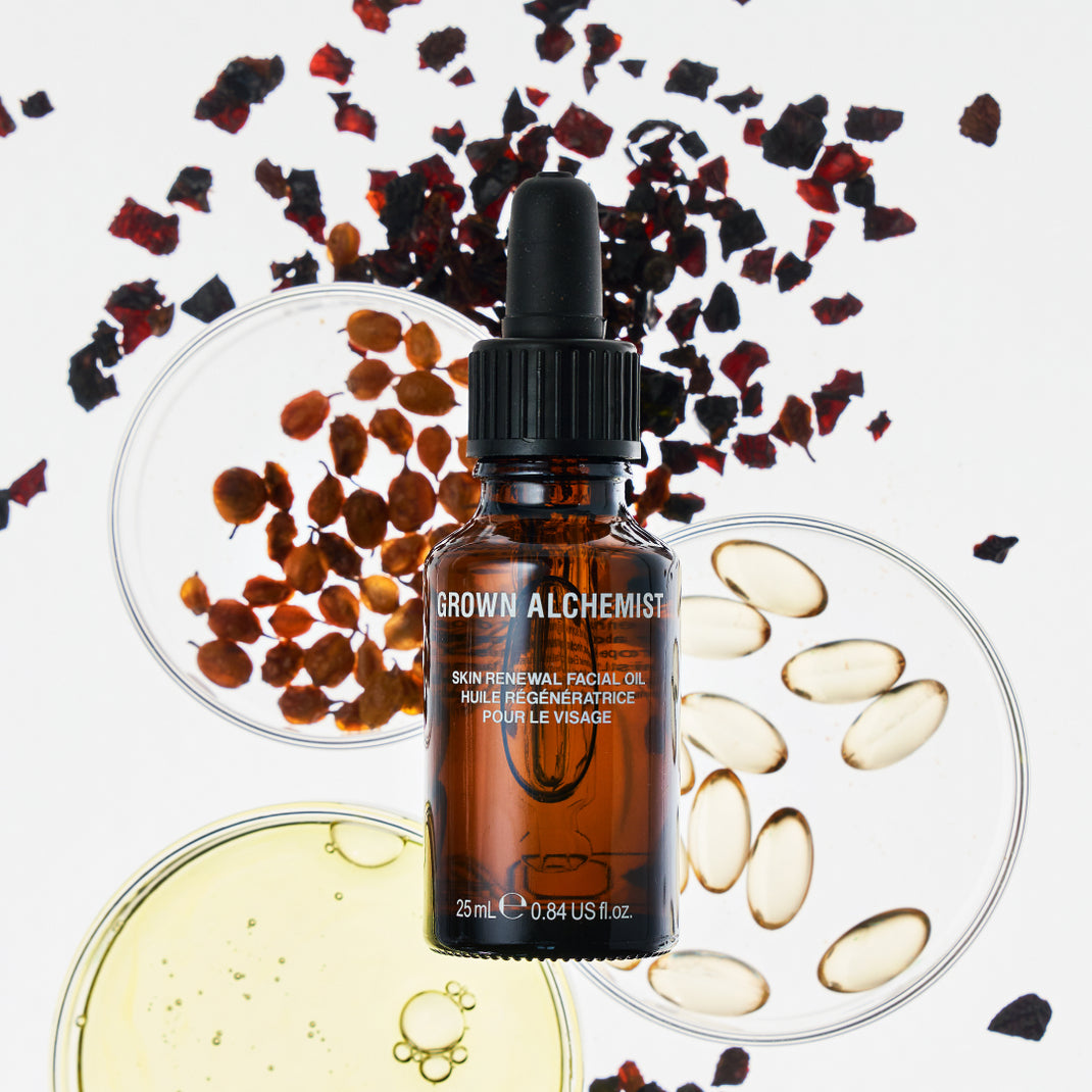 Grown Alchemist Skin Renewal Facial Oil bottle with dropper surrounded by dried flowers and capsules on a white background