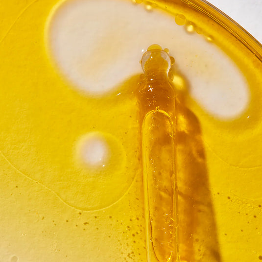 Yellow liquid with a dropper on a yellow background