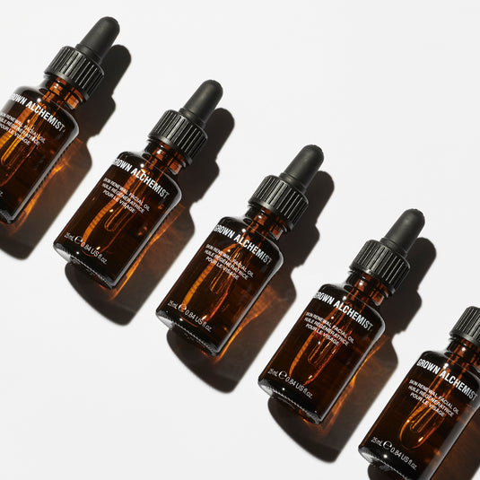 Five brown glass dropper bottles with black caps on a white background, branded 'Grown Alchemist'.