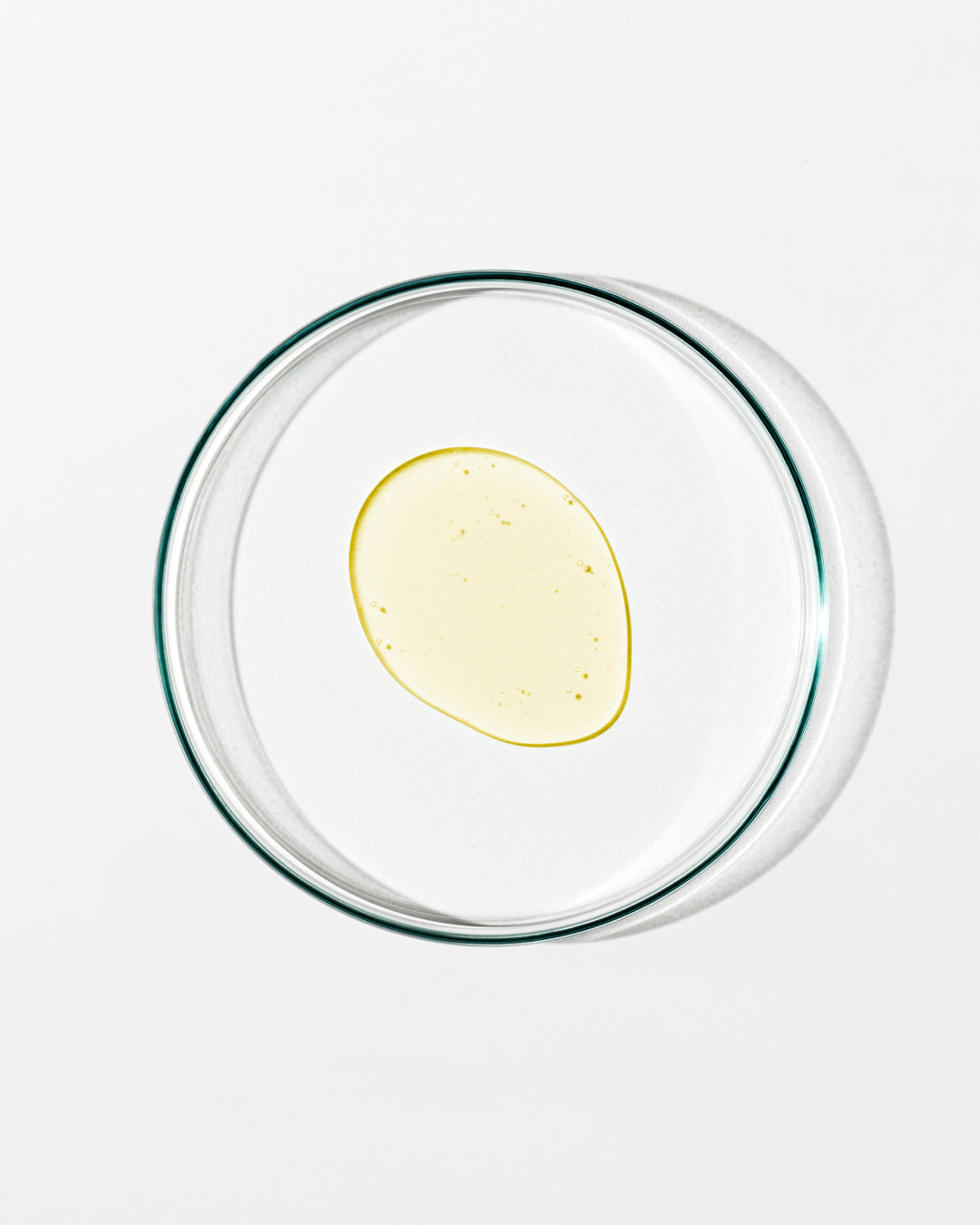 Clear glass bowl with a yellow substance on a white background