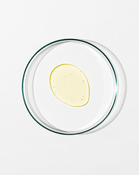 Clear glass bowl with a yellow substance on a white background