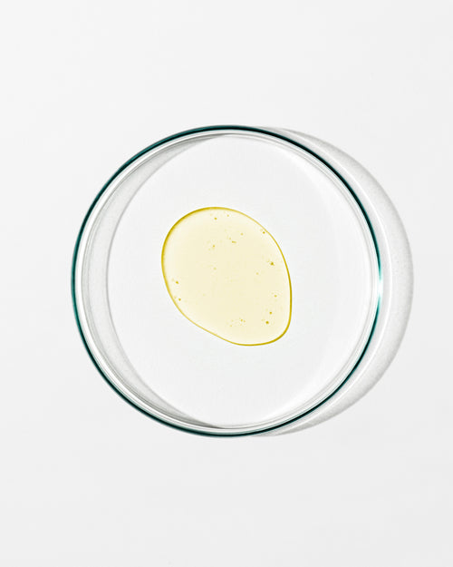 Clear glass bowl with a yellow substance on a white background