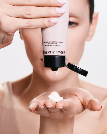 Person holding a skincare product with 'Grown Alchemist' branding