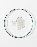Clear glass lid with a small amount of white substance on a white background
