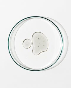 Clear glass lid with a small amount of white substance on a white background
