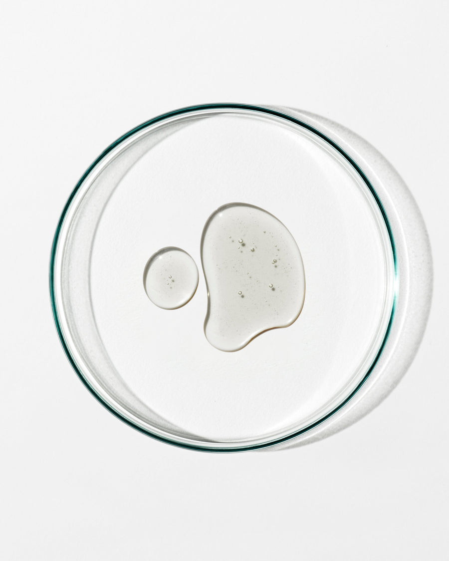 Clear glass lid with a small amount of white substance on a white background