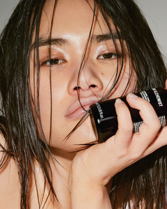 Person holding a cosmetic product with a blurred background