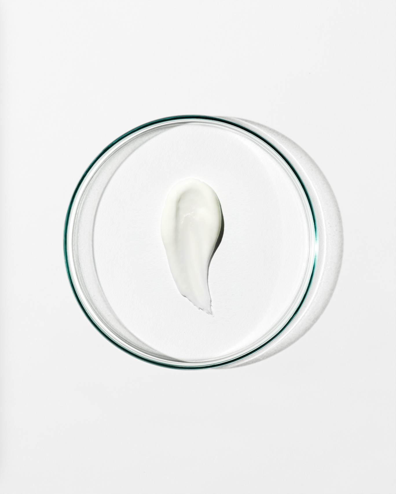 Clear dish with a dollop of white cream against a white background