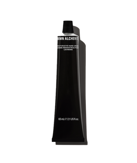 A black bottle of Restorative Hand Cream by Grown Alchemist with white and silver text indicating the product size of 65mL.