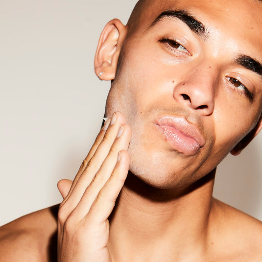 Man touching his face with a neutral background